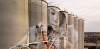 Photo by Rick Pepper - Aerial view of the in-progress Silo Art Project by Australian artist, Guido van Helten on the Ardent Mill grain silos at the gateway of Old Town, Mankato.