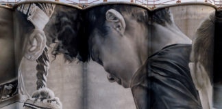 Photo by Rick Pepper - Aerial view of the in-progress Silo Art Project by Australian artist, Guido van Helten on the Ardent Mill grain silos at the gateway of Old Town, Mankato.