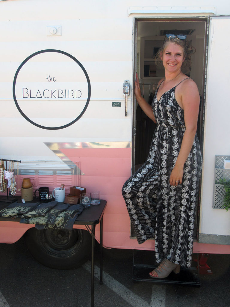 Photo by Grace Brandt - Ali Woods founder and owner of Blackbird LLC in front of the center of the business, Birdie the trailer.
