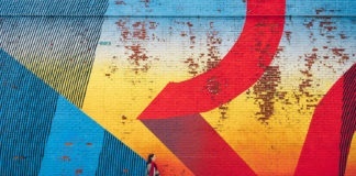 Young girl walking by wall with graffiti in New York