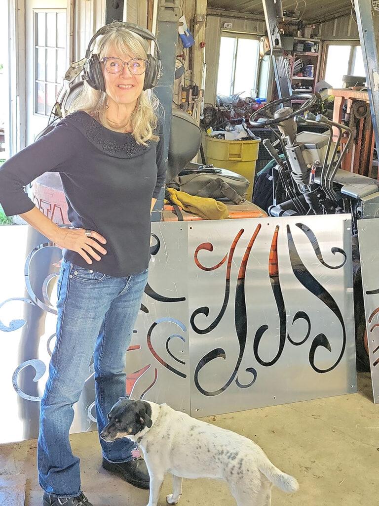 Photo by Don Lipps - Michelle Kaisersatt and Robyn Block's dog Daisy in front of the freshly laser cut steel panels for the Phone of the Wind installation.